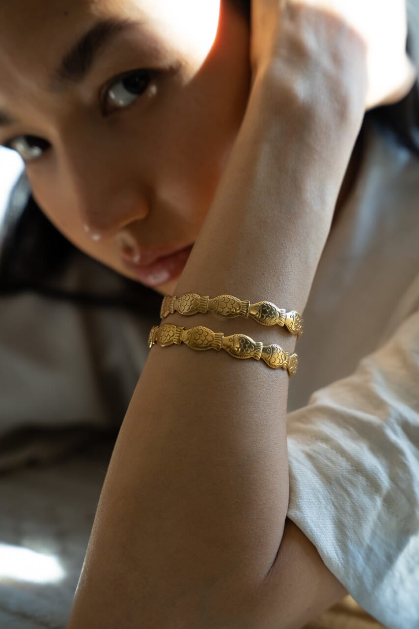 Model wearing 18k gold plated fish bracelets