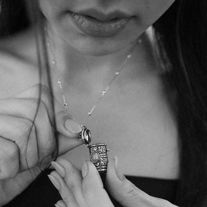 Woman wearing an engraved tibetan mediation pendant with storage
