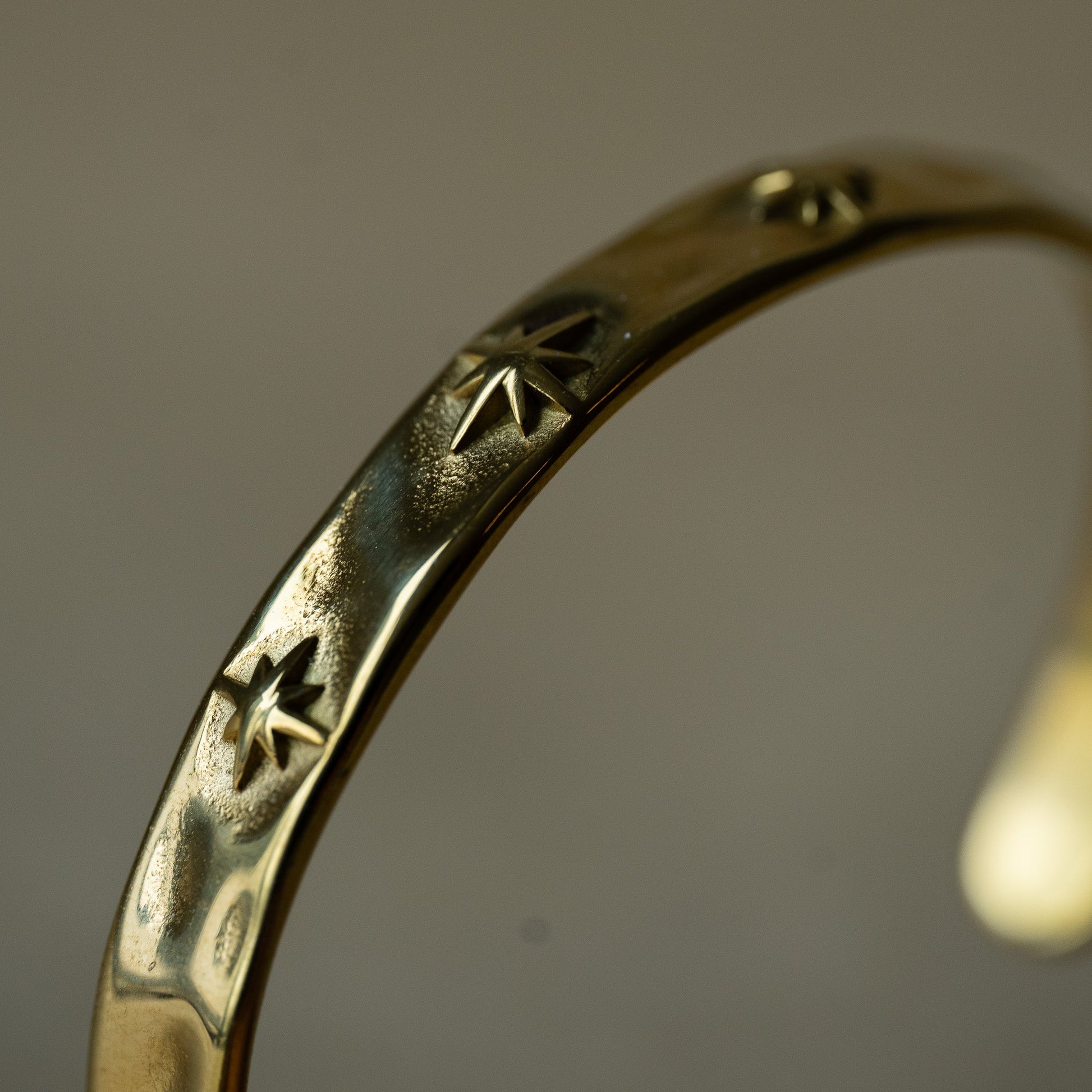 Close up of gold plated bracelet with three stars designs