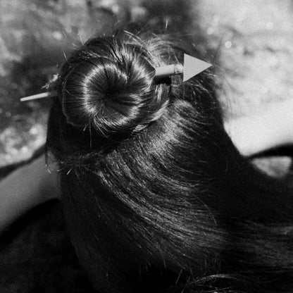 Close-up of a hair bun with a hairpin against a blurred background