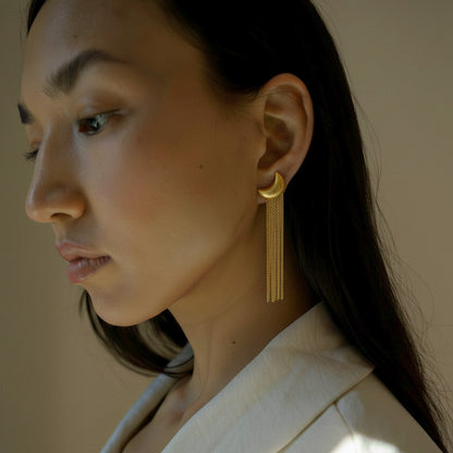 Woman wearing gold plated moon shaped tassel matte finish earrings for formal ocassion