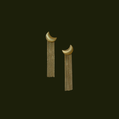 Pair of gold  plated matte finish moon shaped earrings with crescent moon designs on a deep green background