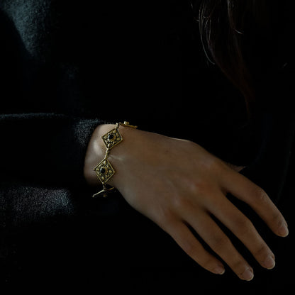 Woman wearing antique golden brass bracelet with black onyx medieval style