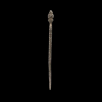 Decorative metal hairpin on a black background