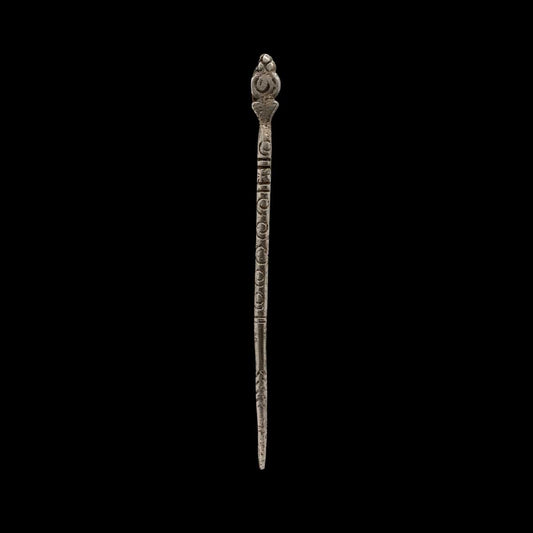 Decorative metal hairpin on a black background