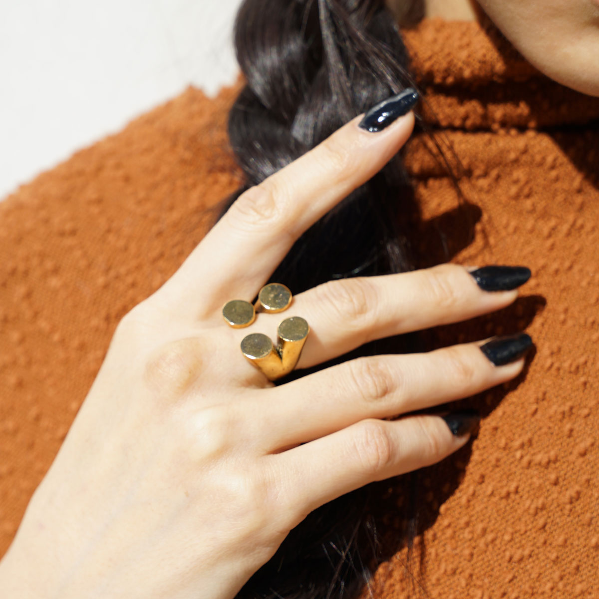 A gold-plated ring with four matte finished circles arranged in a geometric pattern