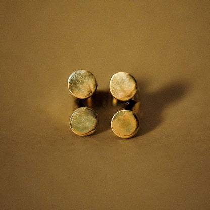 A gold-plated ring with four matte finished circles arranged in a geometric pattern