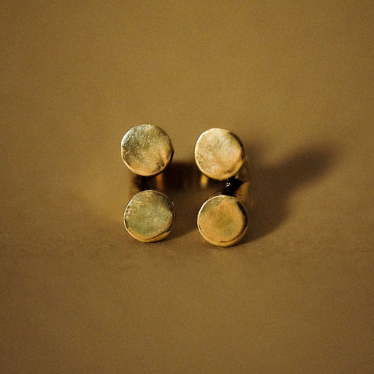 A gold-plated ring with four matte finished circles arranged in a geometric pattern
