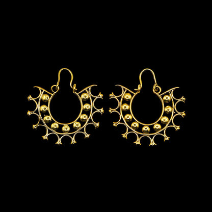 Pair of lightweight intricate designed earrings in a circular geometric pattern kept on stone surface