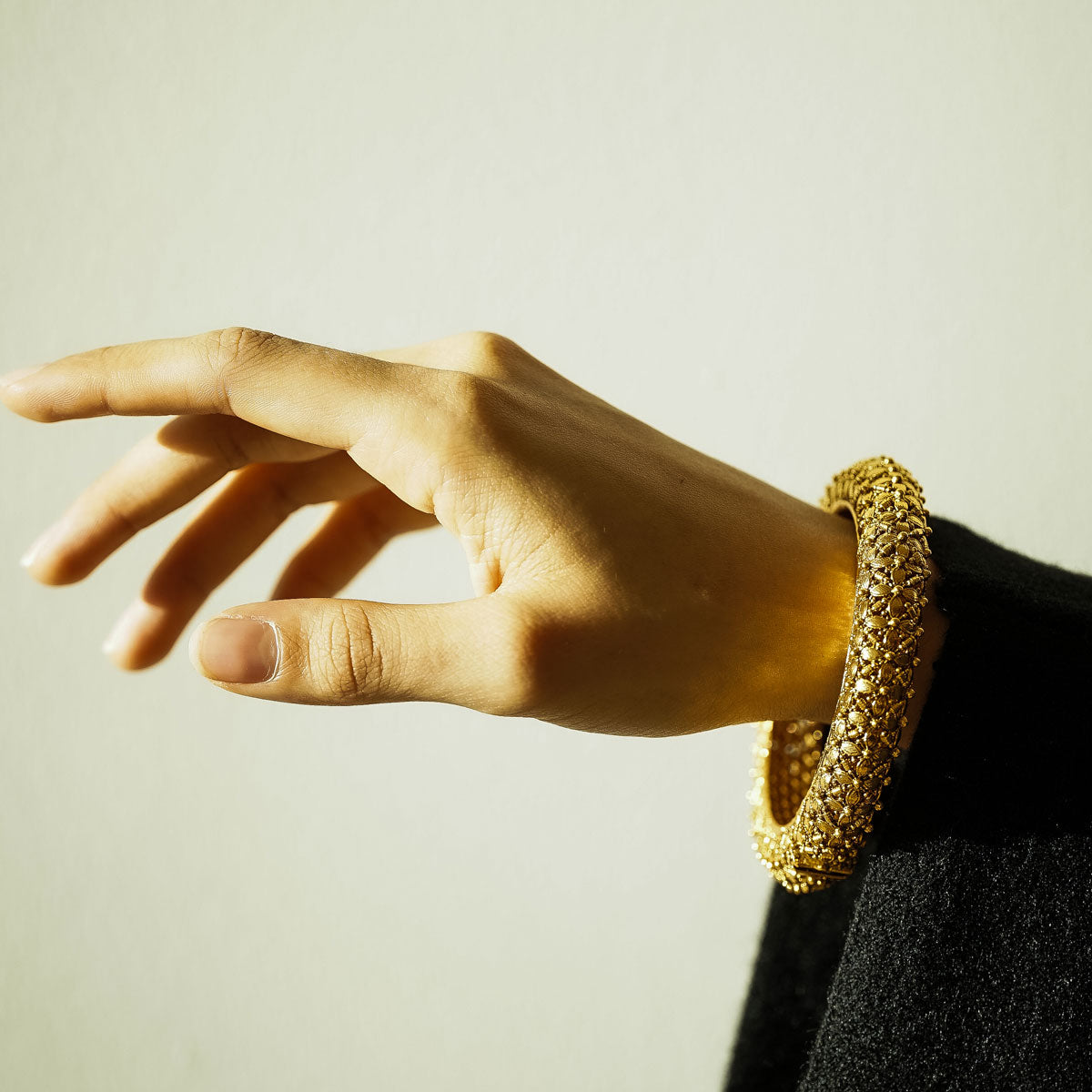 Woman wearing an ornate intricate Indian bangle hinge opening