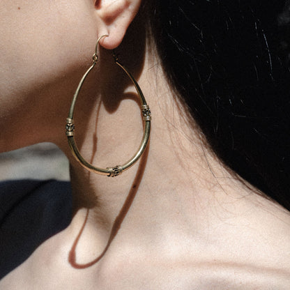 Woman wearing antique south asian golden hoop earrings 