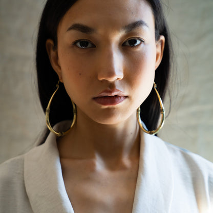 Woman wearing antique south asian golden hoop earrings 
