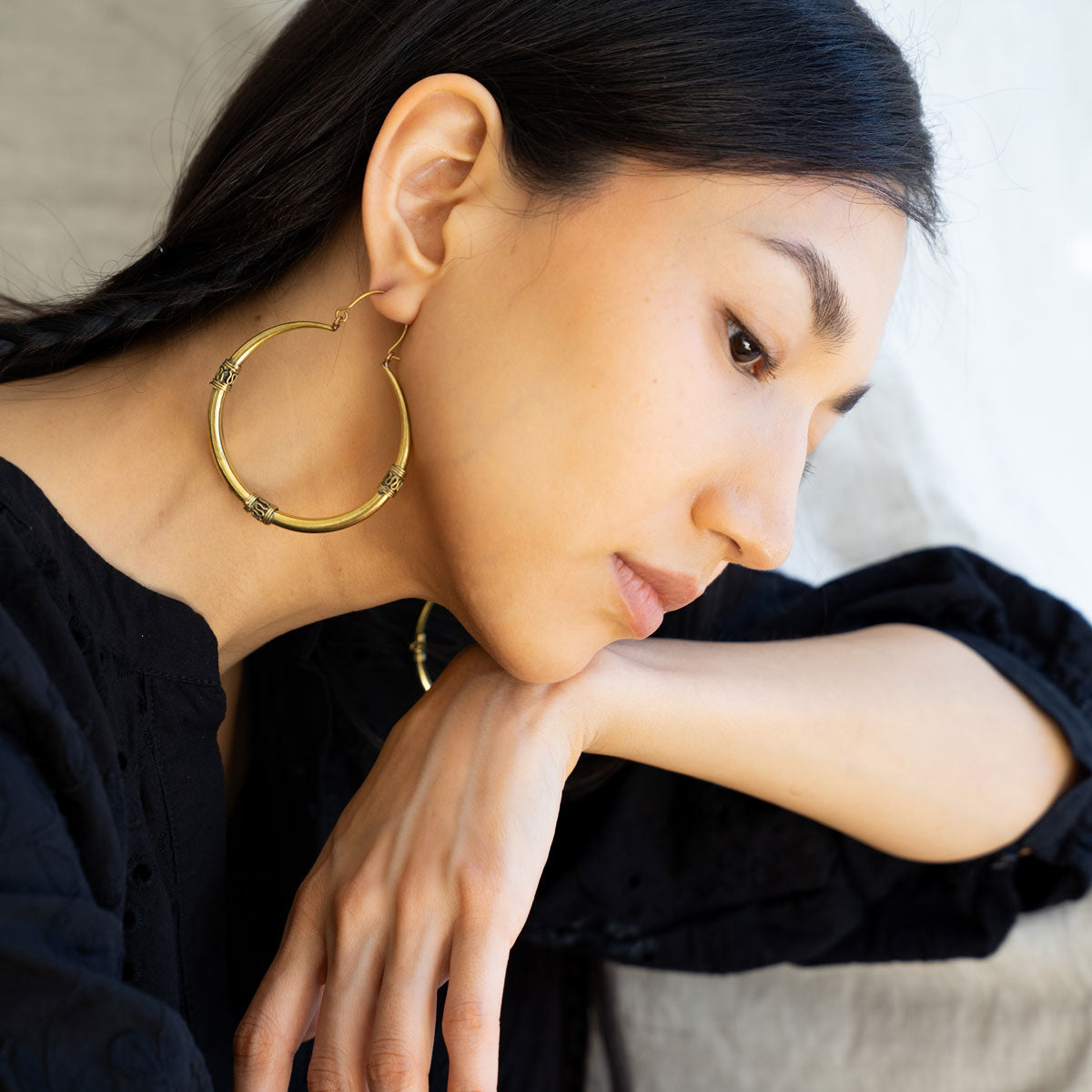 Woman wearing antique south asian golden hoop earrings 