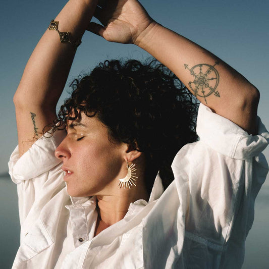 Woman wearing a crescent moon shaped earrings with sun rays