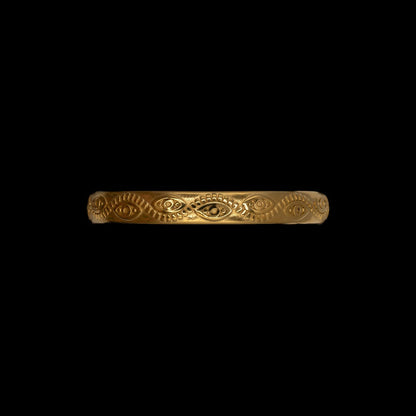 Top view of gold plated bracelet with evil eye pattern