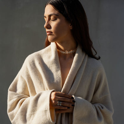 Woman wearing a delicate silver-plated choker necklace and a geometric matte statement ring