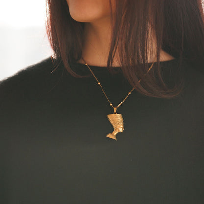 Woman wearing an egyptian pendant Nefertiti's face in brass