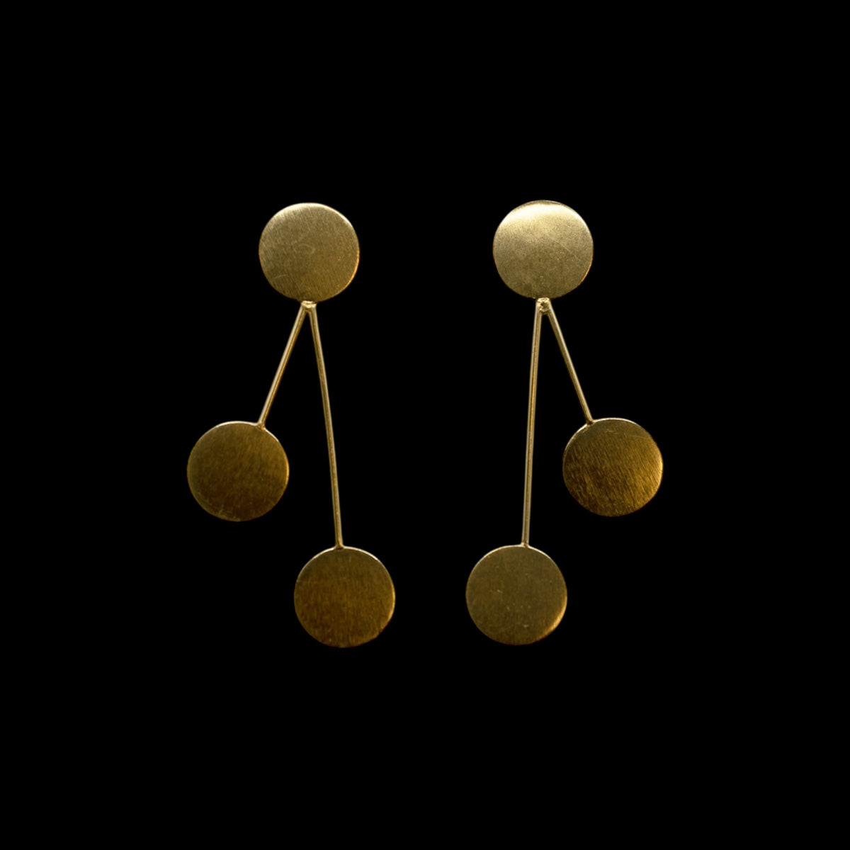 Pair of golden brass earrings with three geometric circles on a black background