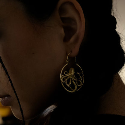 Woman wearing golden octopus earrings 