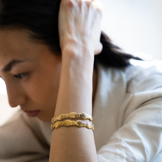 Woman wearing a gold plated fish shaped bracelet set