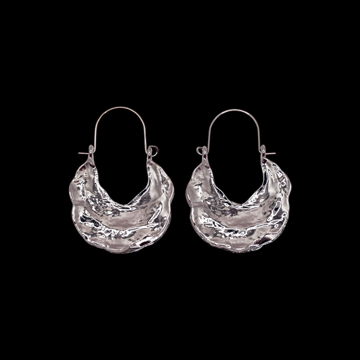Pair of silver textured hoop earrings on a black background