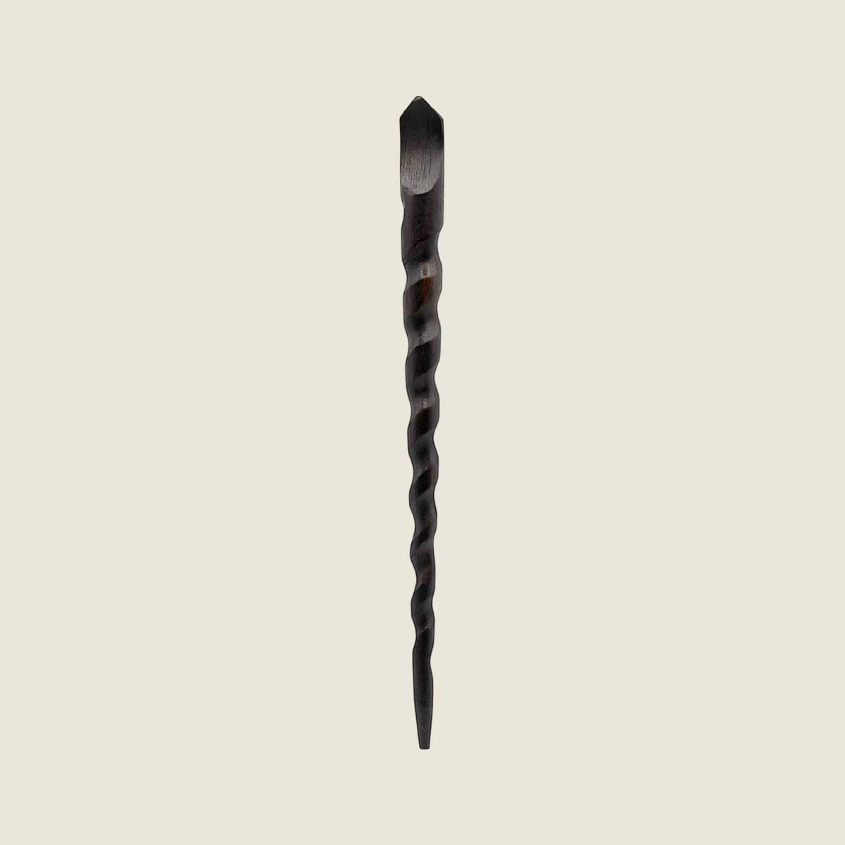 Twisted wooden hair stick wand on a beige background