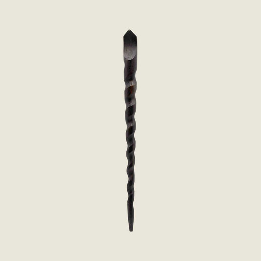 Twisted wooden hair stick wand on a beige background