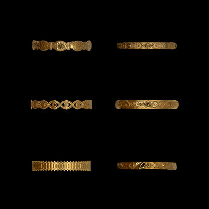 Set of six gold-plated with intricate celestial and ocean themed bracelets on a black background