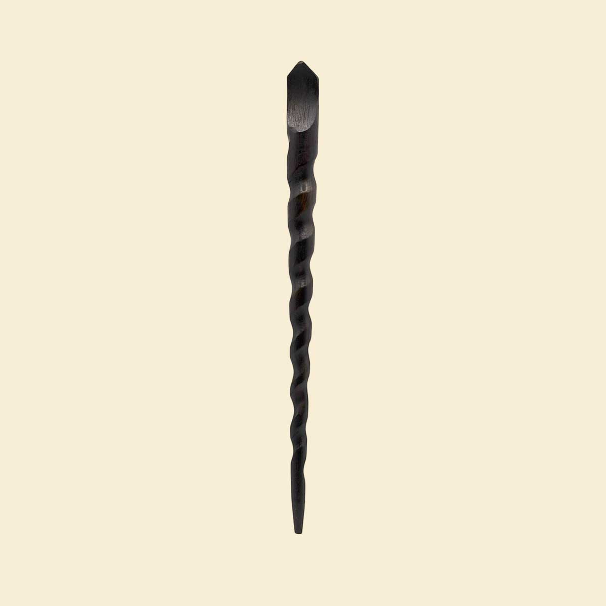 Black twisted wooden wand hair stick on a beige background