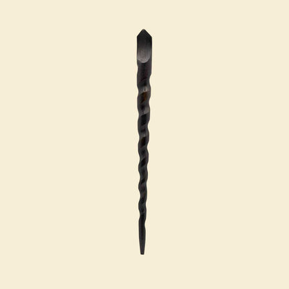 Black twisted wooden wand hair stick on a beige background