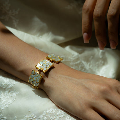 Close up of a gold bracelet with mother of pearls on a wrist 