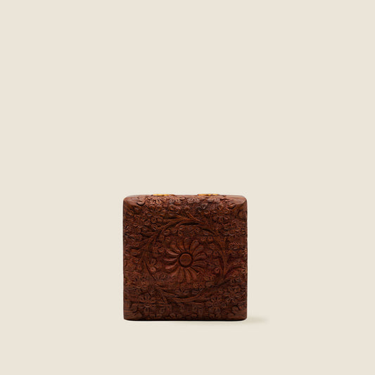 Decorative wooden kashmiri jewellery box with intricate carvings on a beige background