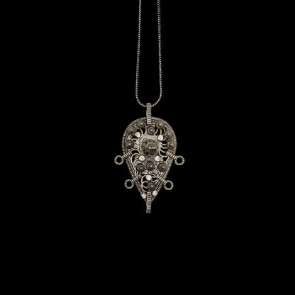 An intricate afghani pendant on a black background