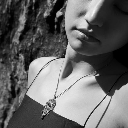 Close-up of a woman wearing an intricate afghani german silver pendant 