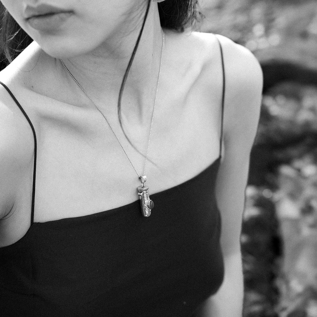 Woman wearing a golden brass pendant with a green gemstone